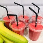 Healthy and pink smoothies with straws in them, with some big bananas laying next to them, from Best.