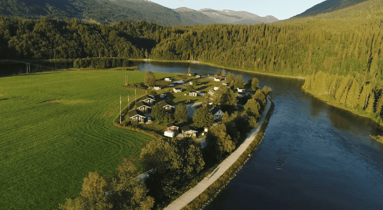 Korgen Camping, seen from above, located right next to Røssåga river and in one corner of a great acre.