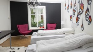 One of the colorful and artistic bedrooms at Mileperlen Gallerihotell with the artist and owner’s own paintings. 