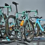 Lots of blue bikes attached to the roof of several cars during the bike race, Artic Race.