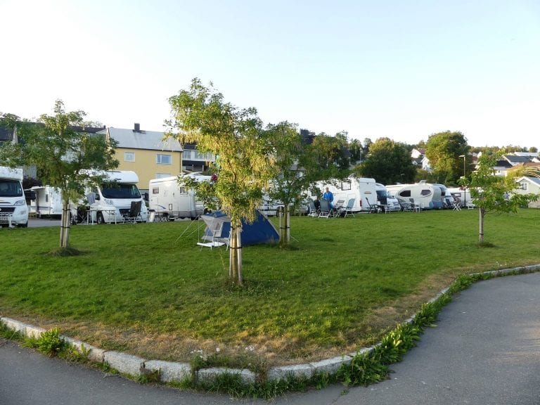 Parking for mobile caravan at the marina in the center of Hemnesberget, next to a lawn where one can put up a tent.