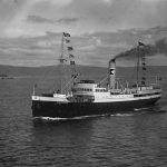 An old black and white photo of the ship DS Nordnorge on the coast.