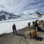 A handfull people getting ready to cross the glacier Austre Okstindbre, glacier and mount Oksskolten in the background.
