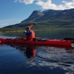 Kayaker at Tustervatnet lake, on a quiet day in great mountain environments.