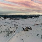 White mountain landscape with pink sky overlooking Korgfjellet Mountain lodge