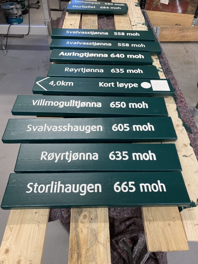 Lots of hiking signs ready to be hung up at different mountain tops with info on the name and the height of the mountain.