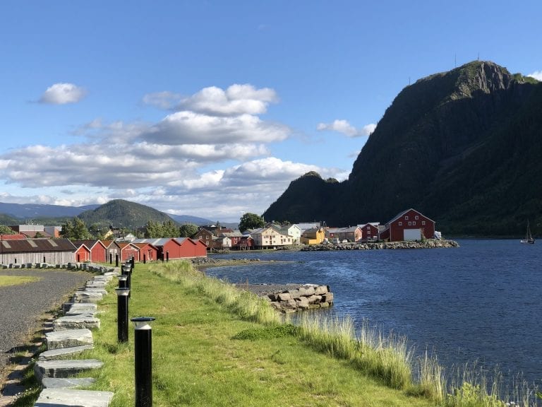Colorful houses next to the fjord in Mosjøen with the tall mountain, Øyfjellet in the background on a sunny summer day.