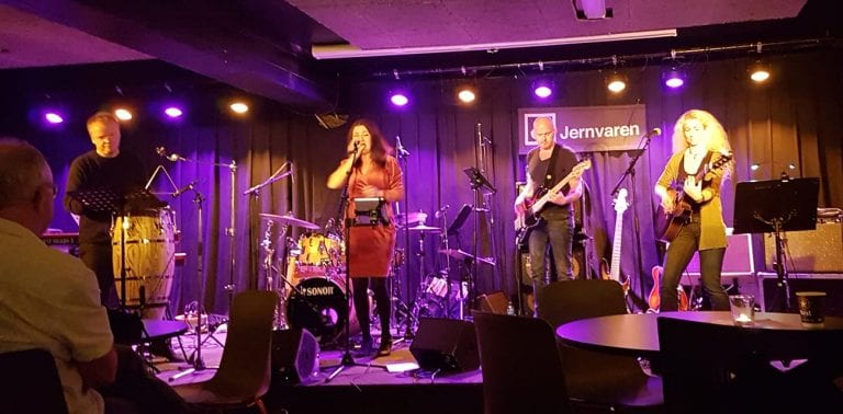 Concert at Jernvaren with band playing on a stage lit up in purple.